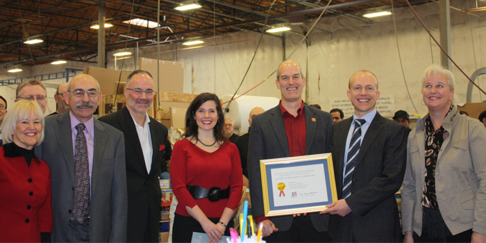 Jim Mischel receiving the Export Achievement Award from Congressman Larsen, flanked by senior Electric Mirror employees and officials from the Export Assistance Cen